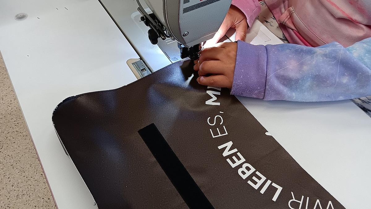 Fertigstellung einer nachhaltigen Laptoptasche im Rahmen des Upcycling-Comebags-Projekt von Hofmann Personal.