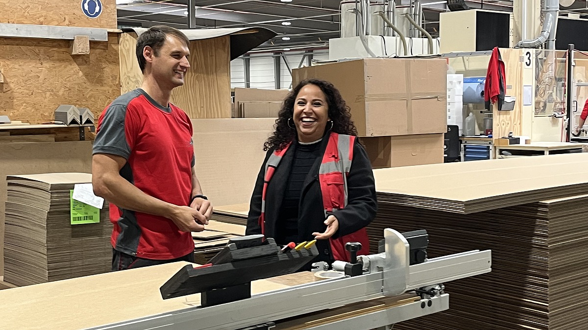 Mitarbeiter im Gespräch mit einer Hofmann-Personalbetreuerin in der Produktionshalle des Verpackungsherstellers