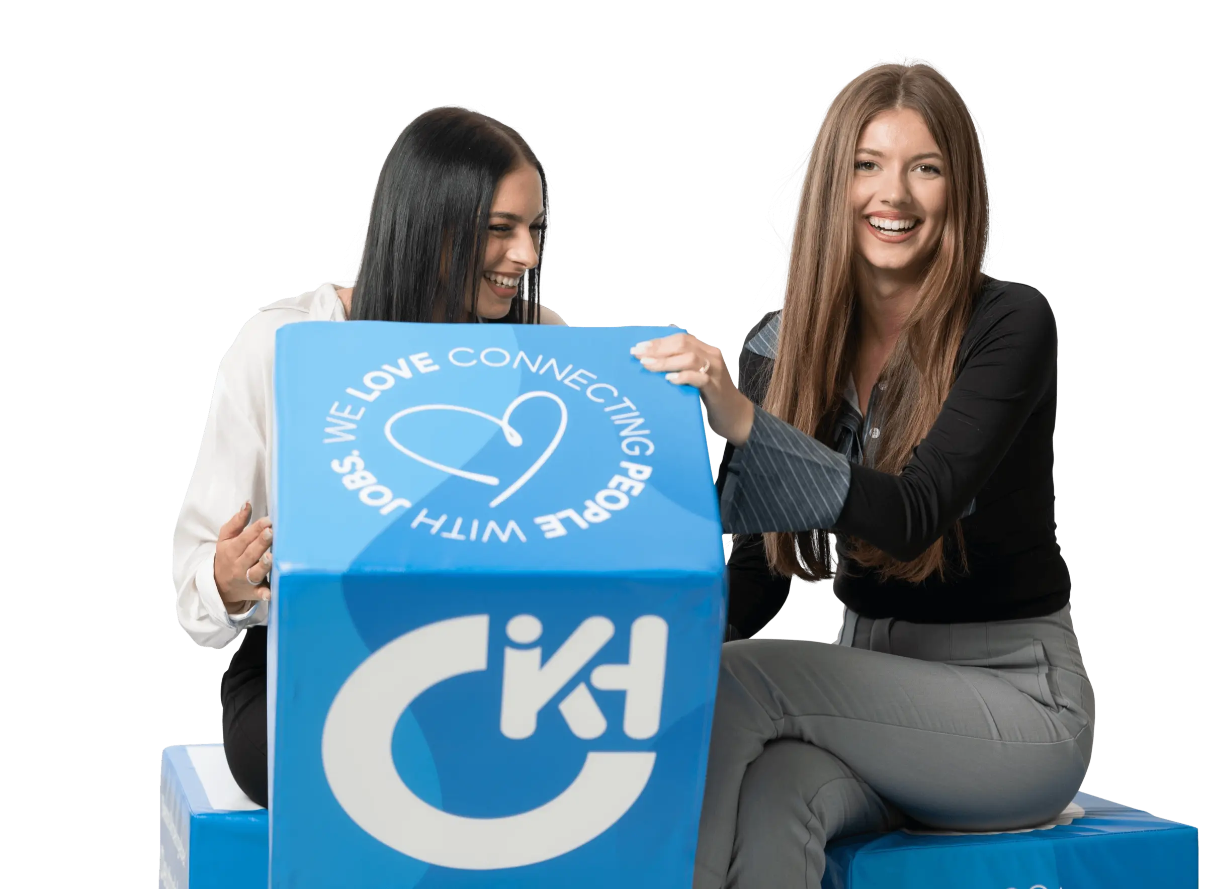 Zwei Auszubildende von Hofmann Personal mit blauem Würfel, der den Purpose "We love connecting people with jobs" zeigt.