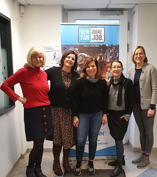 Gruppenbild mit Frauen; im Hintegrund Poster mit Hofmann Kampagne "Kein Fan ohne Job"