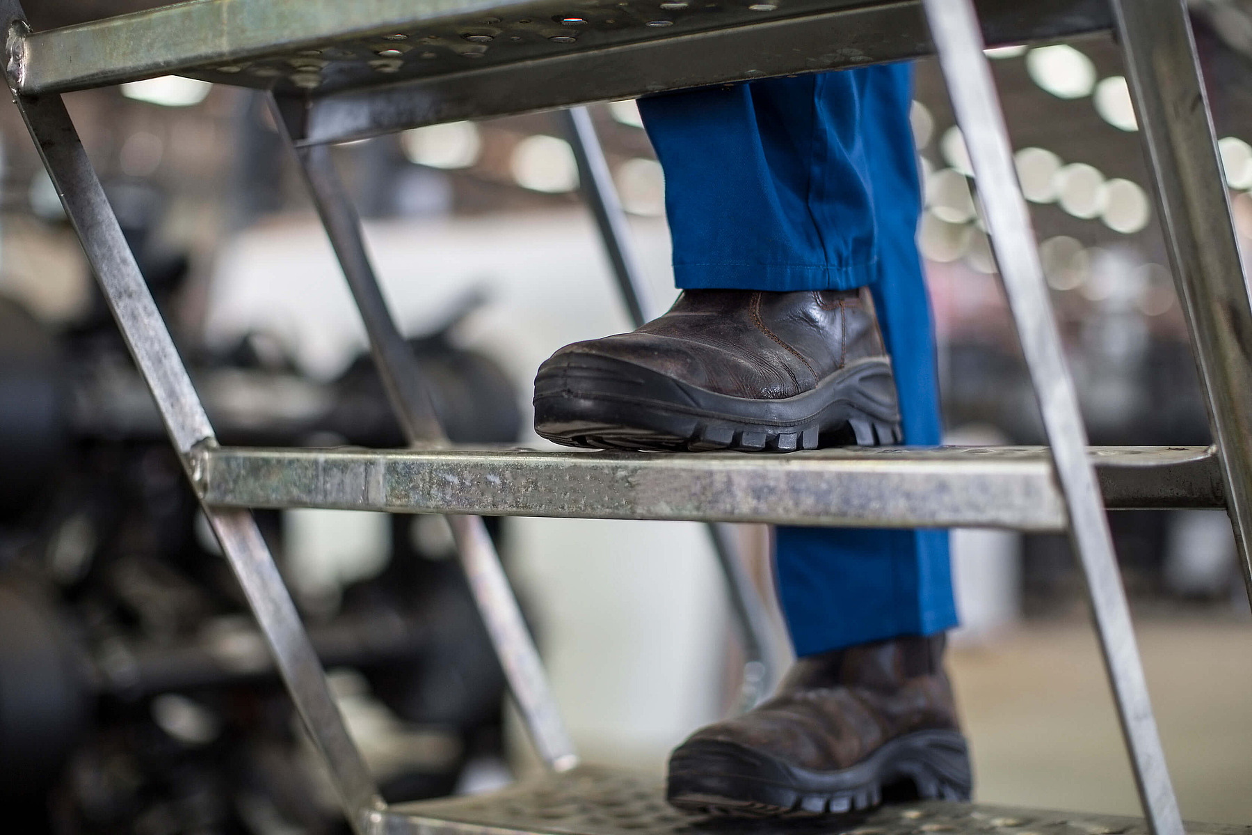 Mitarbeiterin mit Warnweste füllt Unterlagen aus und sitzt in einem Schulungsraum