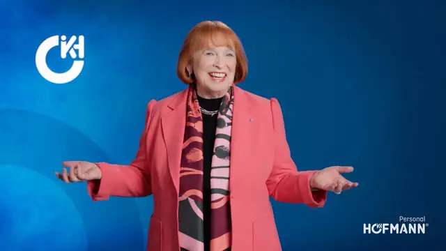 Ingrid Hofmann, Geschäftsführerin, im pinken Blazer mit Schal vor blauem Hintergrund und Hofmann Personal Logo.