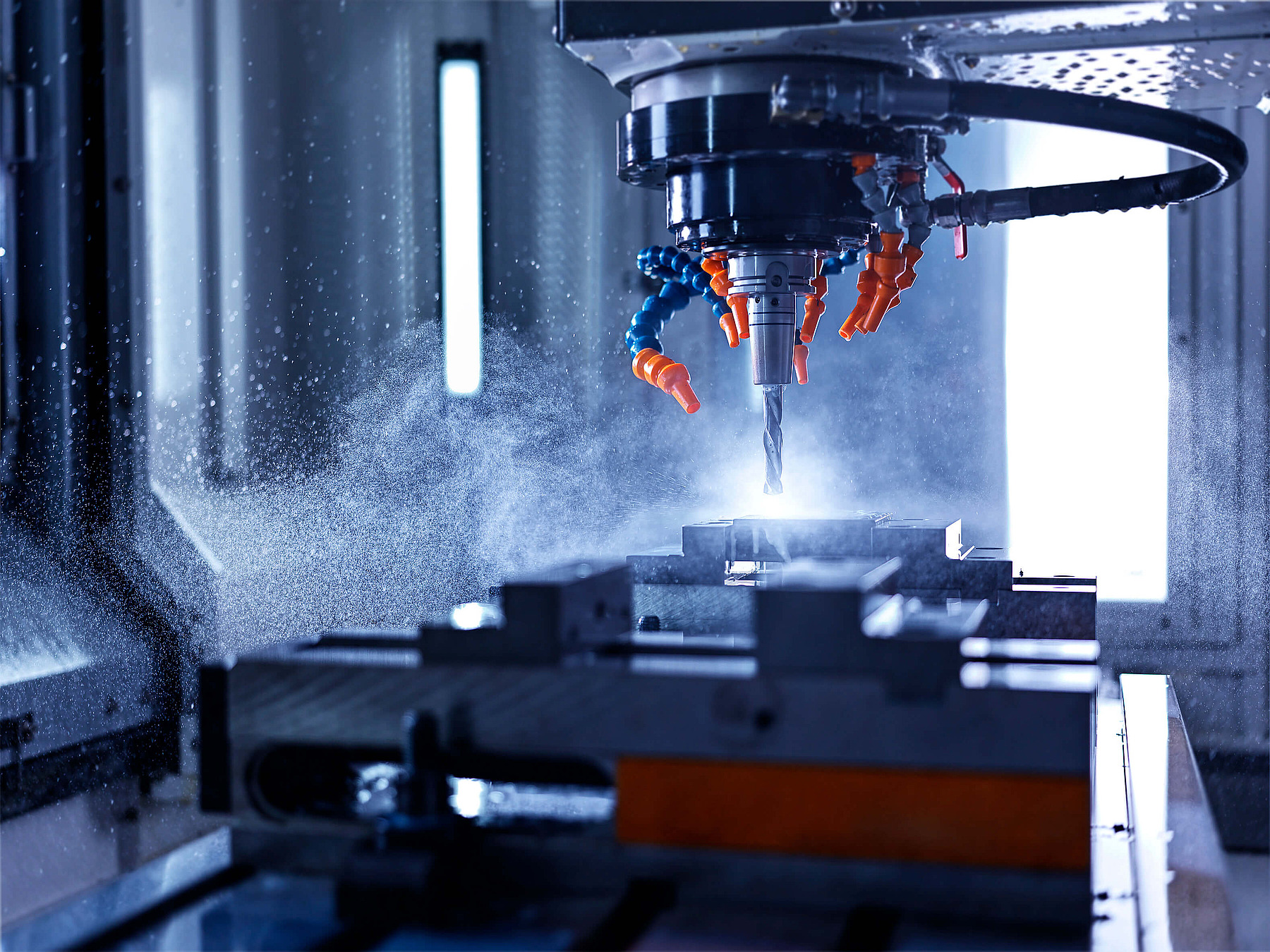 CNC-Fräsmaschine bei der Metallbearbeitung mit Kühlmittelsprühung, symbolisch für technische Berufe in der Zeitarbeit bei Hofmann Personal.