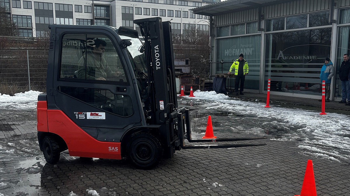 Ein Gabelstapler fährt durch ein Hütchen-Parcours bei der Gabelstaplergrundausbildung von Hofmann Personal.