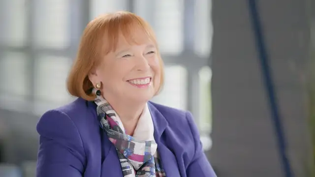 Ingrid Hofmann, Geschäftsführerin, mit lila Blazer und gemustertem Schal berichtet über Brieffreundschaft und Entdeckung Südafrikas.