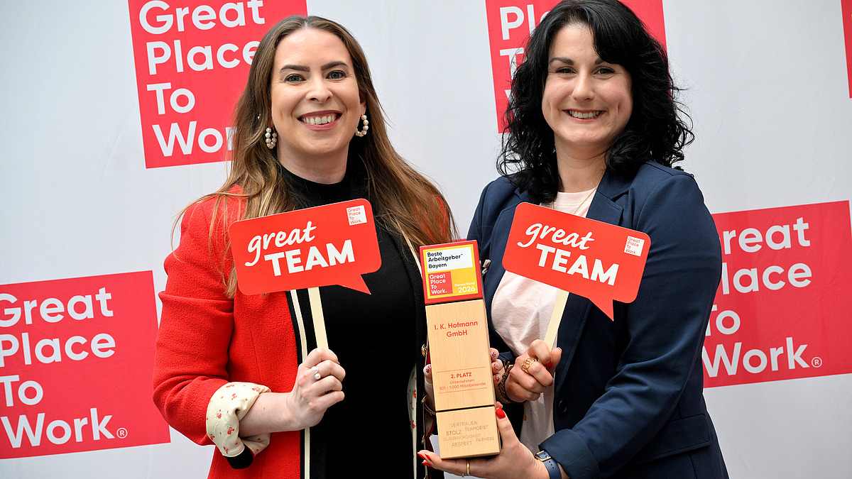 Sonja Heinrich Mitglied des Executive Committee von Hofmann Personal und eine Mitarbeiterin präsentieren stolz die Auszeichnung Beste Arbeitgeber Bayerns 2026.