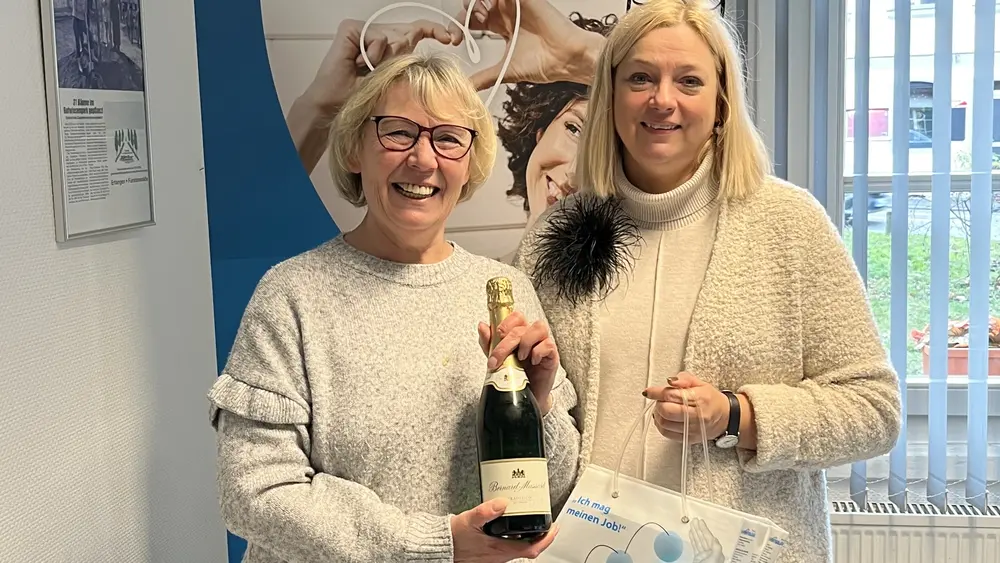 Mitarbeiterin von Hofmann Personal, steht neben einer lächelnden Kundin, die ihren Traumjob gefunden hat.