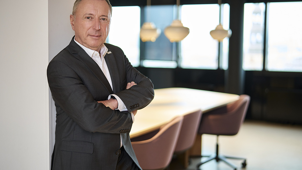 Mitglied des Executive Committee in Businesskleidung vor einem modernen Konferenzraum