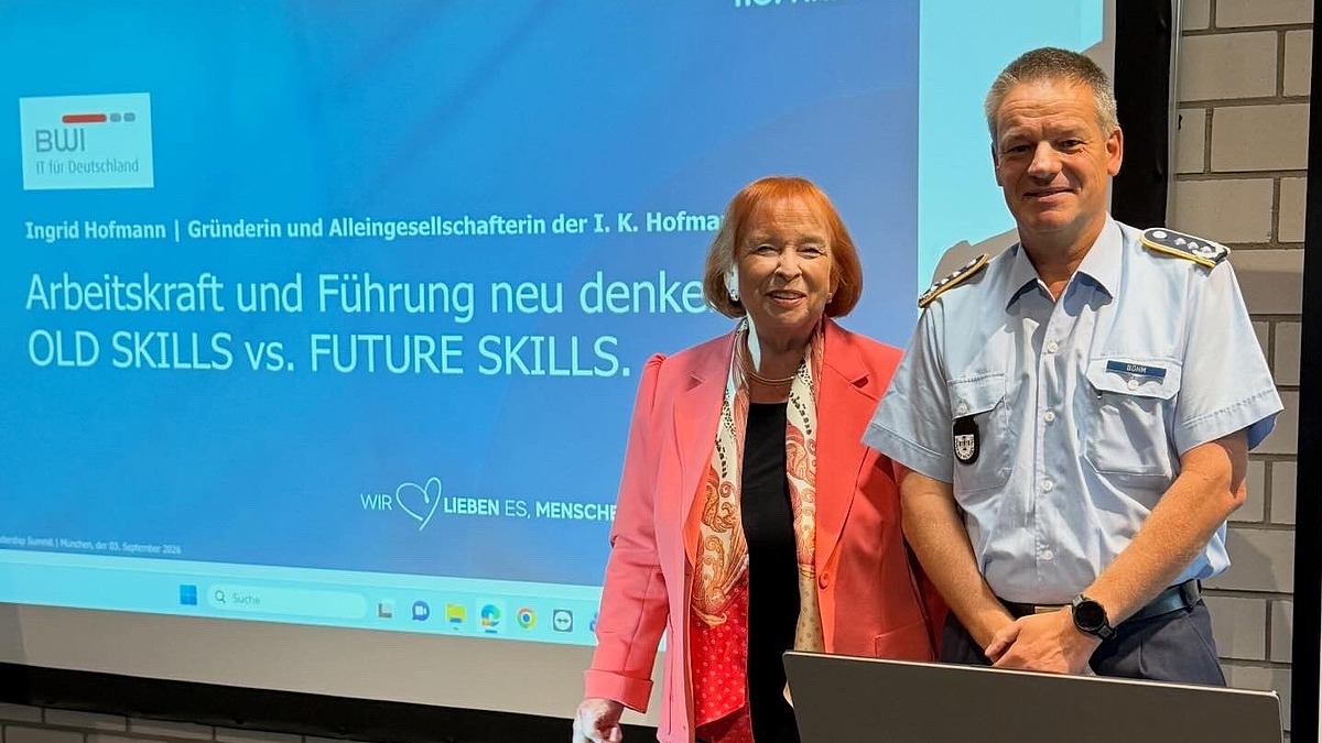 Ingrid Hofmann, Geschäftsführerin von Hofmann Personal, steht lächelnd neben einem Mann beim Leadership Summit 2026.