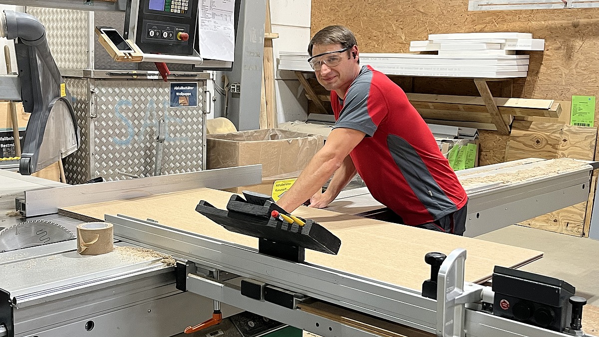 Mitarbeiter an einer Holzverarbeitungsmaschine in einer Werkhalle, unterstützt durch Hofmann Personal und TRICOR