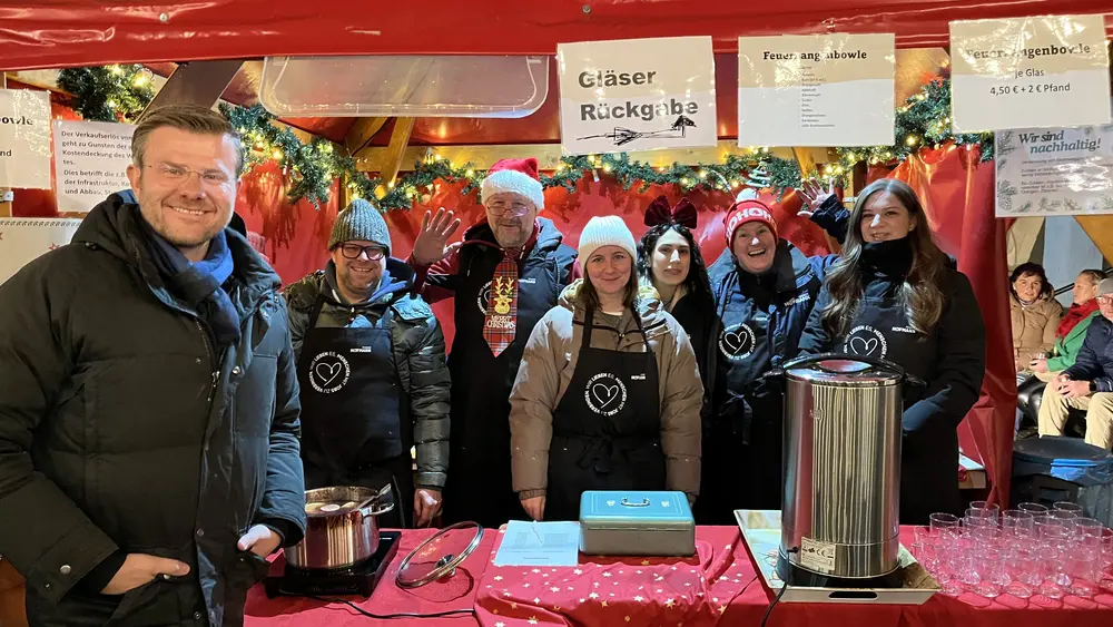 Gruppenfoto mit Oberbürgermeister Marcus König am Stand von Hofmann Personal beim Weihnachtsmarkt Langwasser.