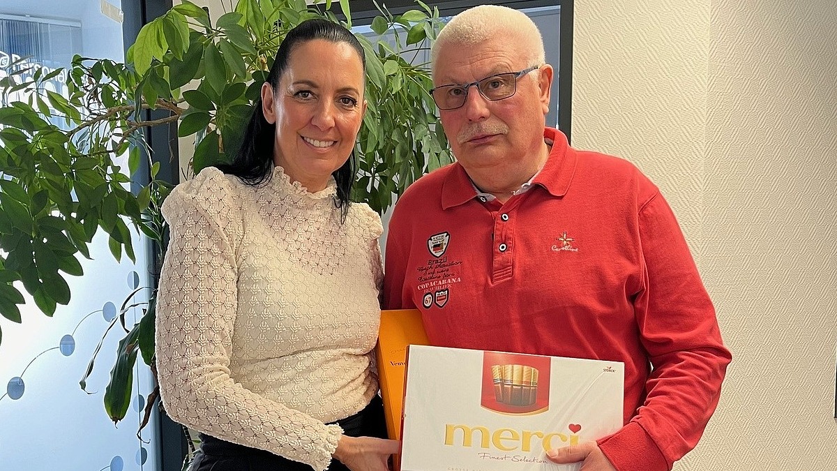 Einem Mitarbeiter wird zum Ruhestand ein Geschenk überreicht, symbolisch für Zusammenhalt und Teamgeist bei Hofmann Personal.