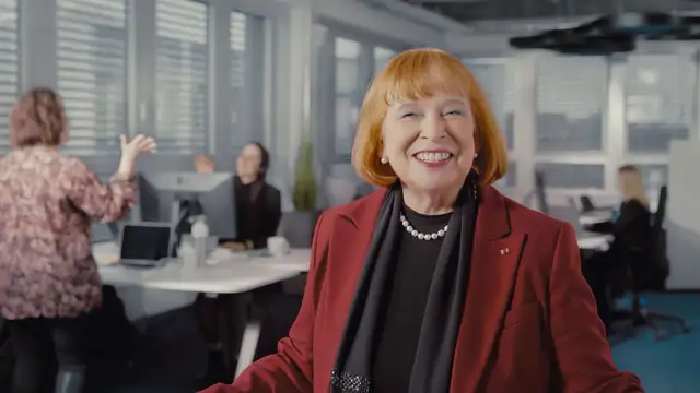 Ingrid Hofmann, Geschäftsführerin, im roten Hosenanzug mit Perlenkette in modernem Büro bei Hofmann Personal.